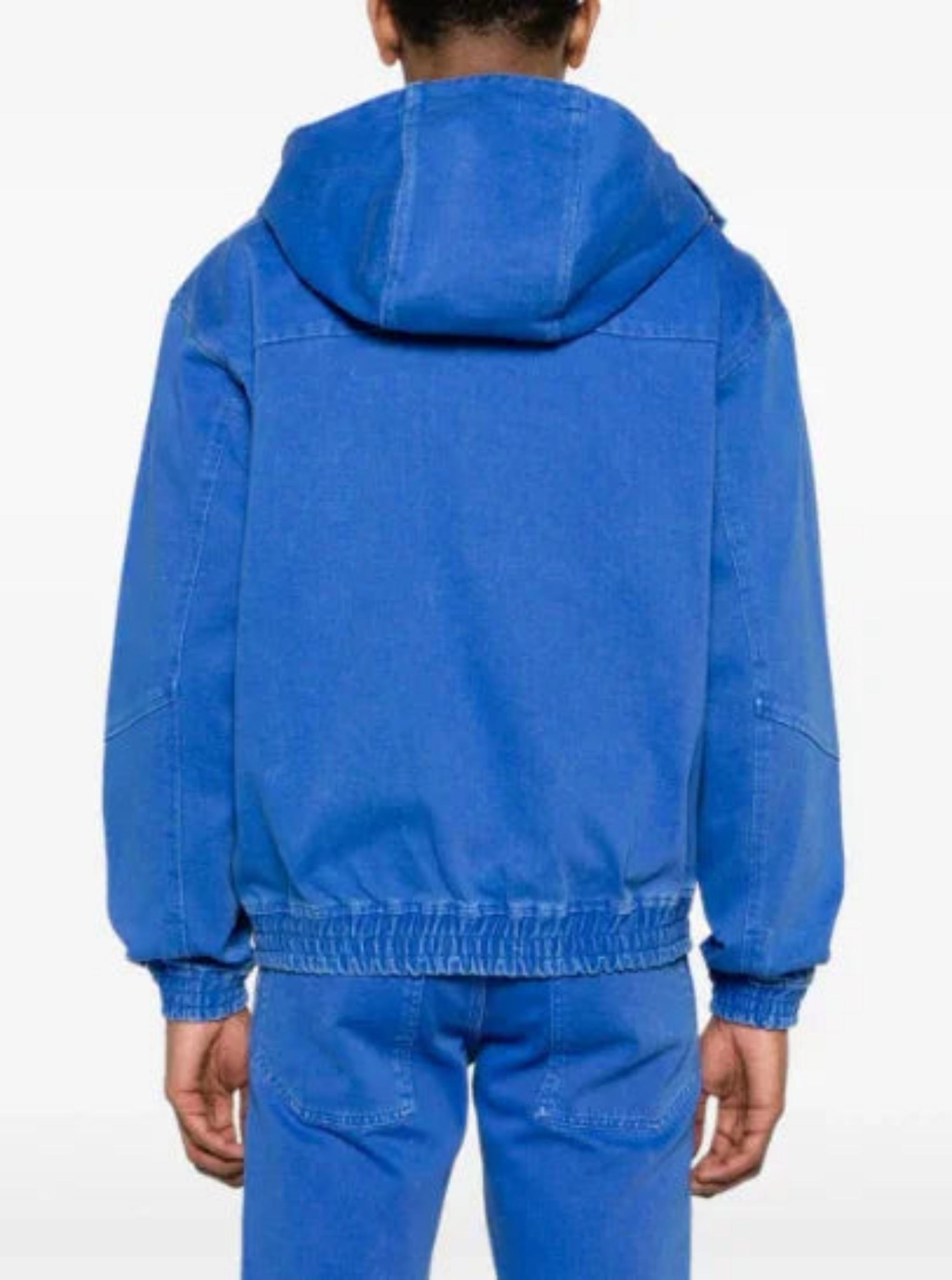 Back view of person wearing bright blue hooded jacket and matching blue pants against white background