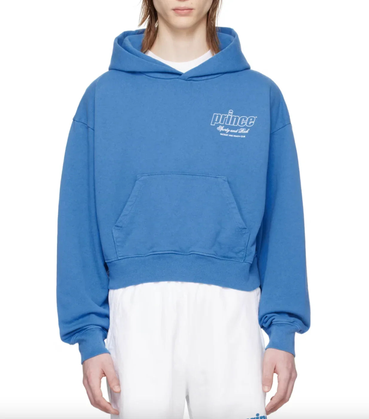 Cropped blue Prince hoodie with front pocket worn over white shorts on model
