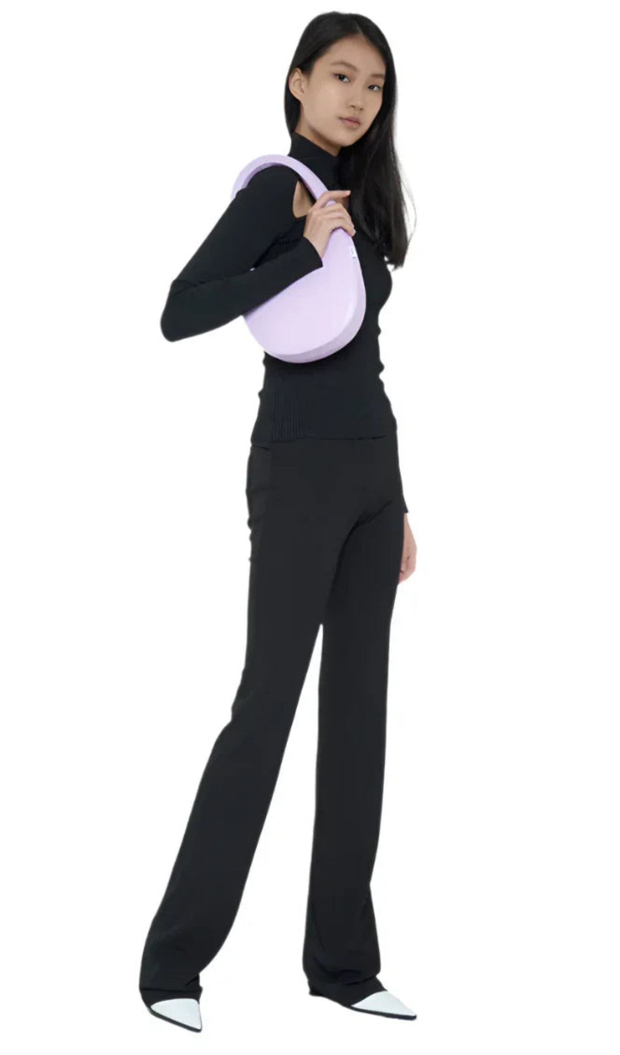 Woman in black turtleneck and pants holding a lavender shoulder bag and wearing white pointed shoes