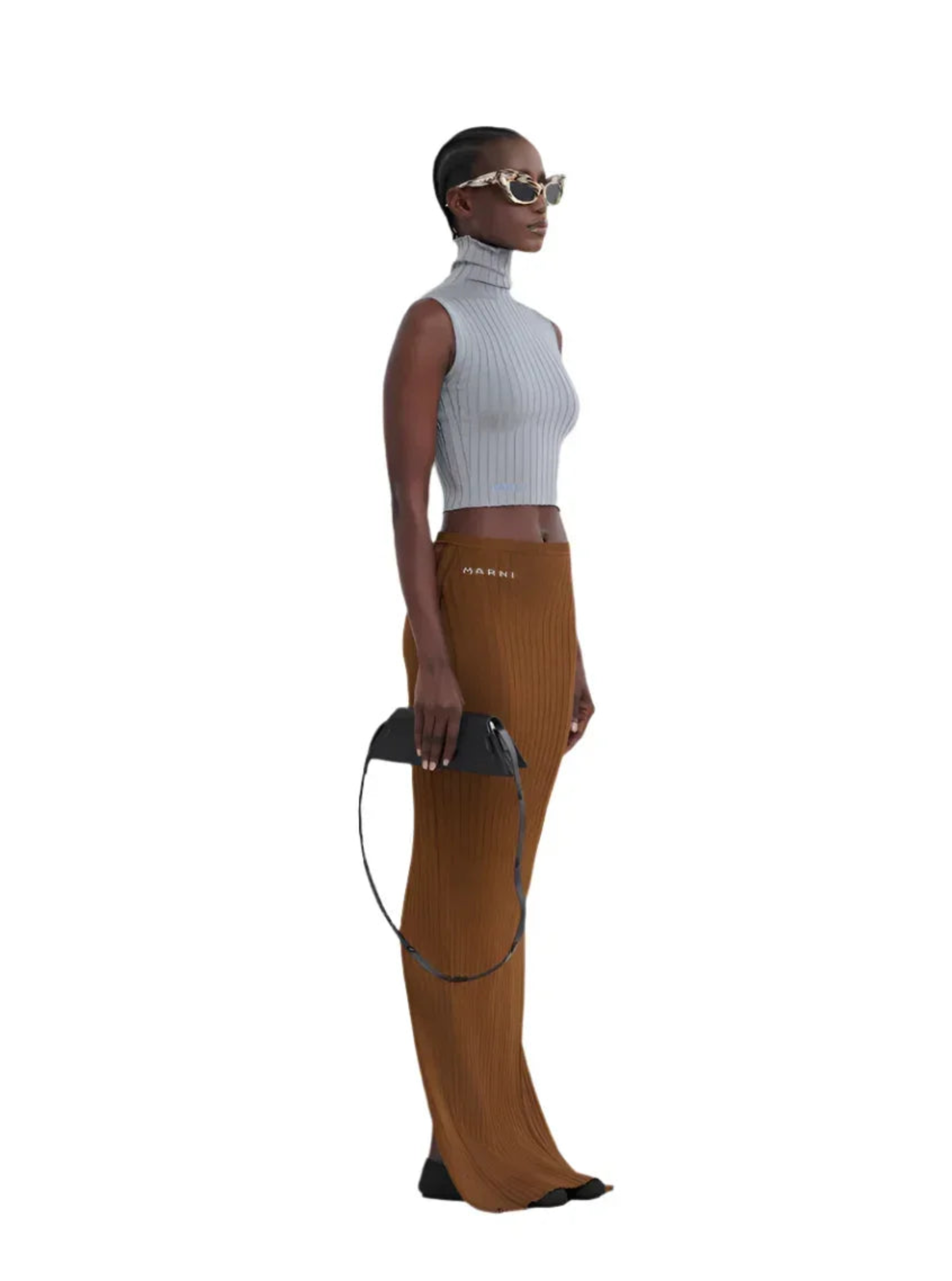 Stylish woman in gray sleeveless turtleneck crop top and brown Marni ribbed maxi skirt holding black purse