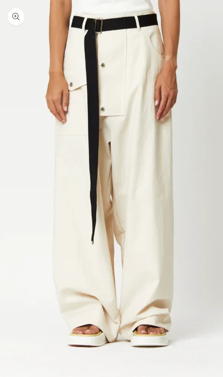 Wide-leg cream pants with black belt and front flap pocket, paired with platform sandals