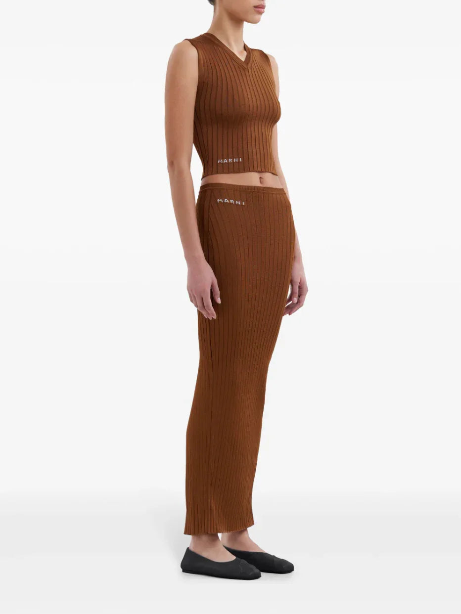 Model wearing brown ribbed Marni sleeveless top and matching long skirt with black flats on white background