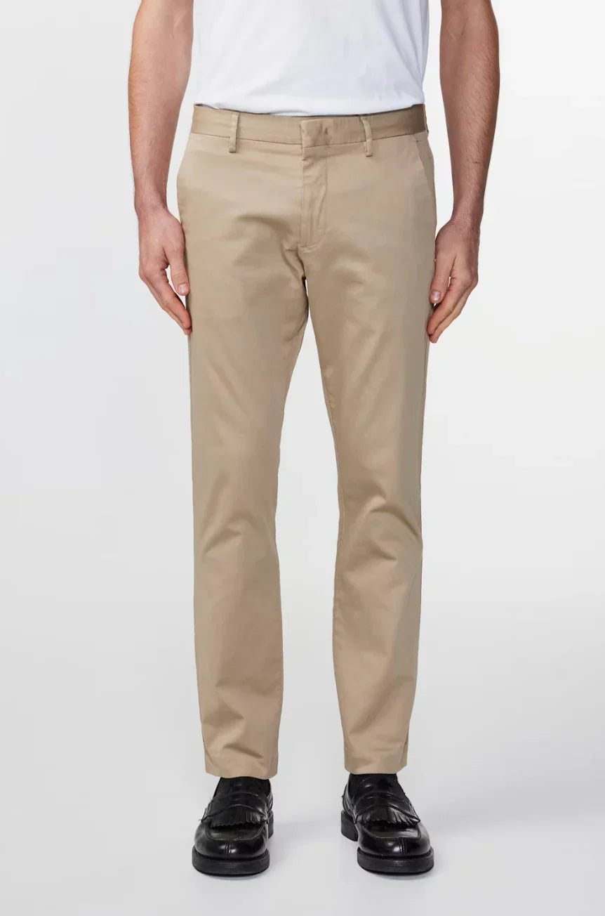 Men's beige chino pants paired with black dress shoes on a white background