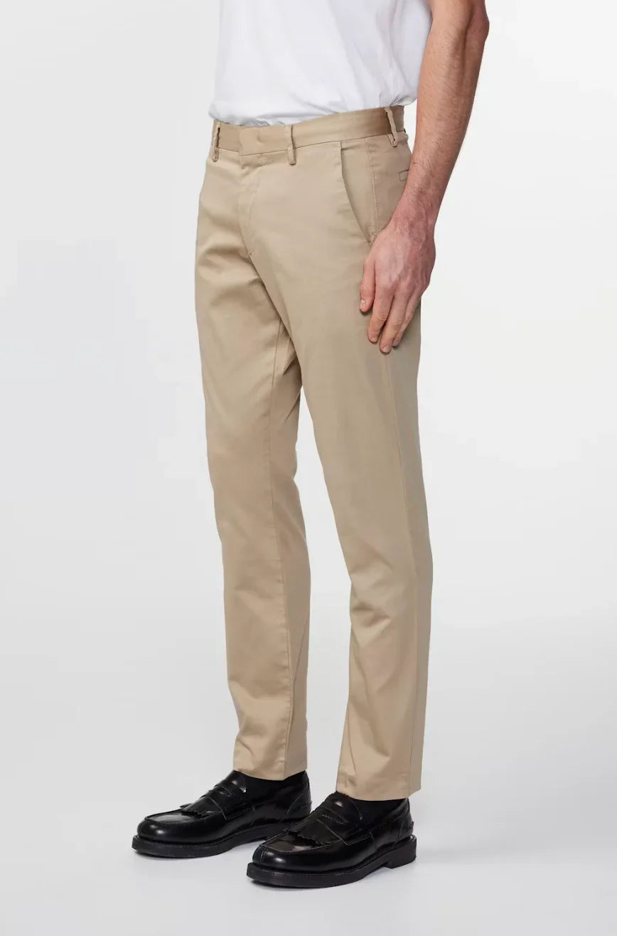 Man wearing beige slim-fit casual pants paired with black loafers and white shirt