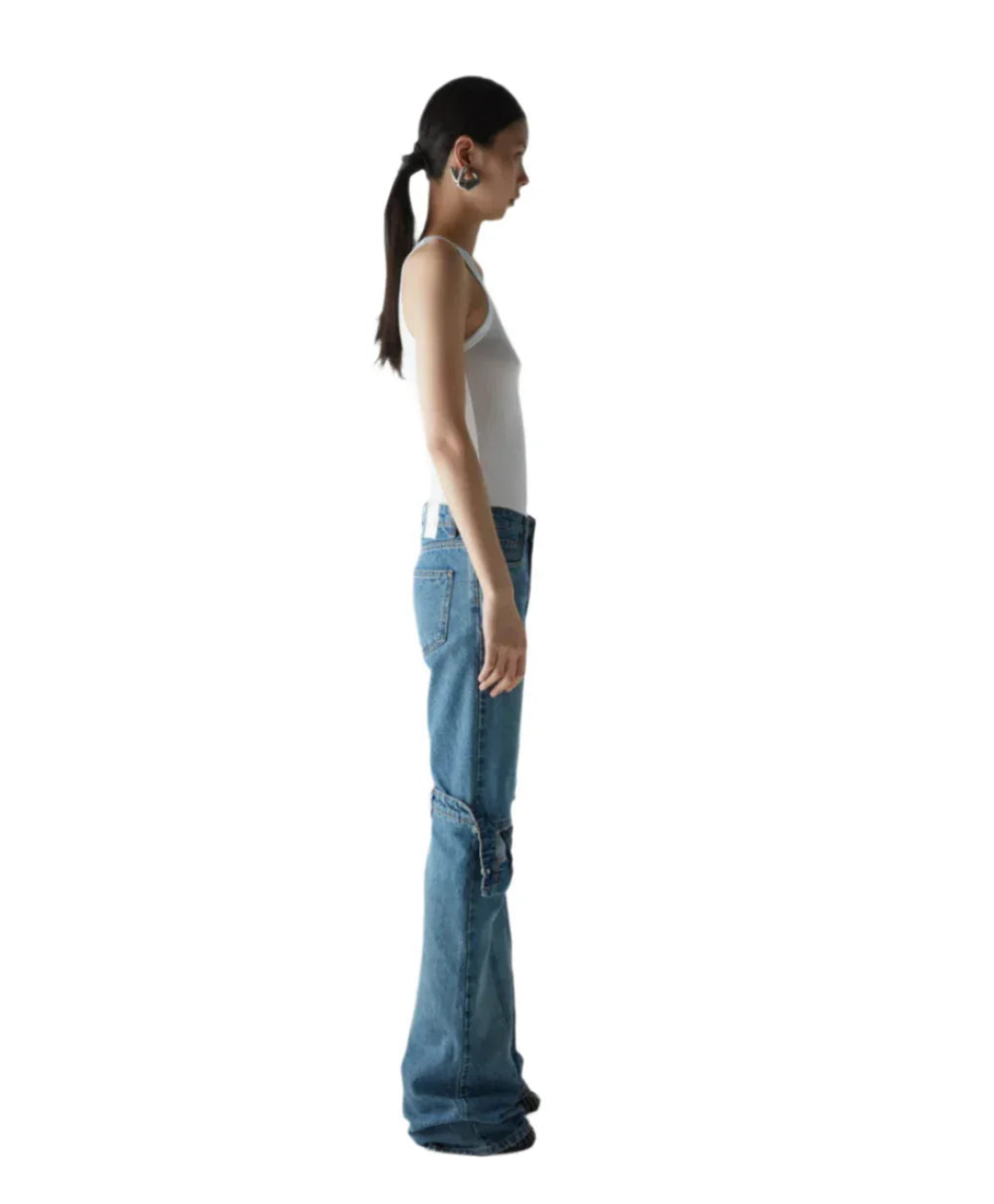 Side view of woman wearing white tank top and wide-leg blue jeans with cargo pockets