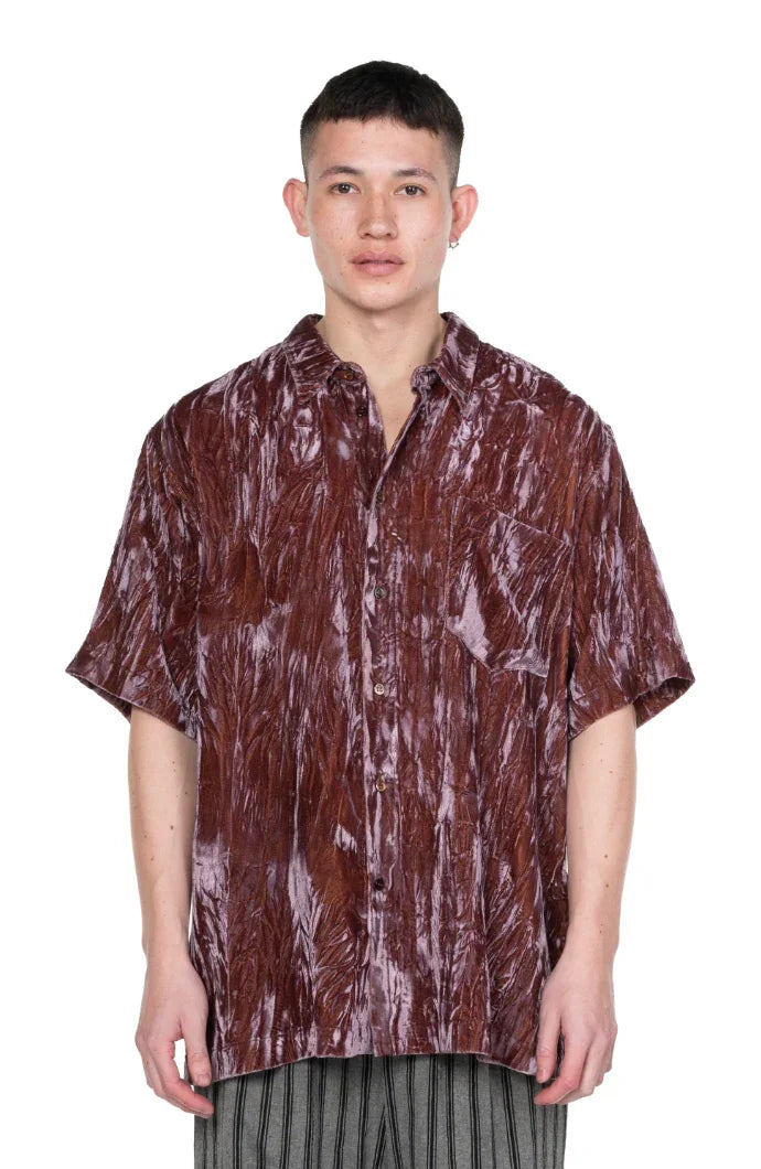 Man wearing a brown crushed velvet short-sleeve shirt with front pocket and buttons
