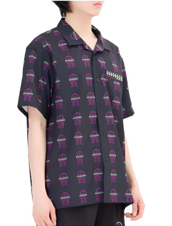 Person wearing black short-sleeve button-up shirt with purple and green jellyfish pattern