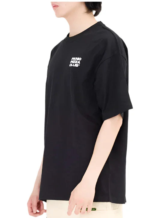 Person wearing black oversized t-shirt with white Print Pizza Club logo on chest