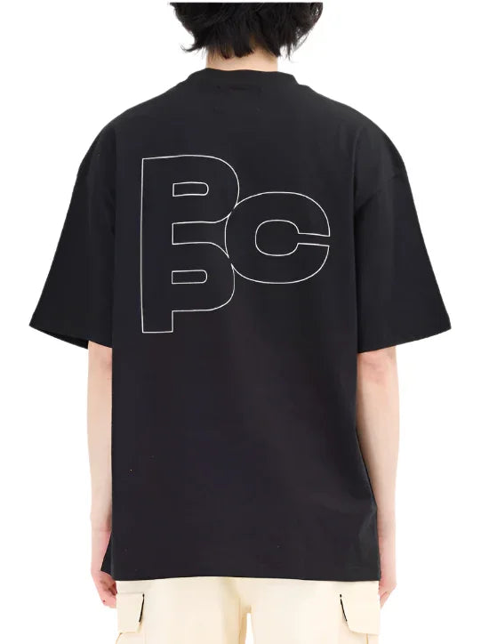 Back view of person wearing black T-shirt with large white outlined letters PPC