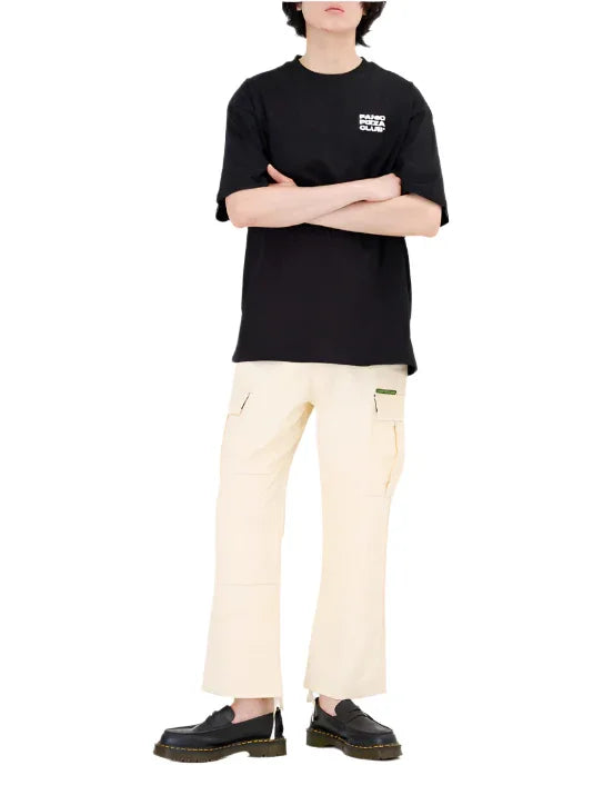 Man wearing black graphic tee with faro guard club text, cream cargo pants, and black leather shoes