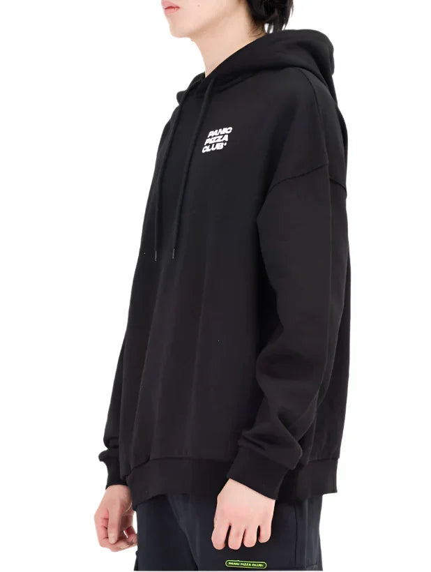 Side view of a person wearing a black hoodie with white small text logo on chest and black pants