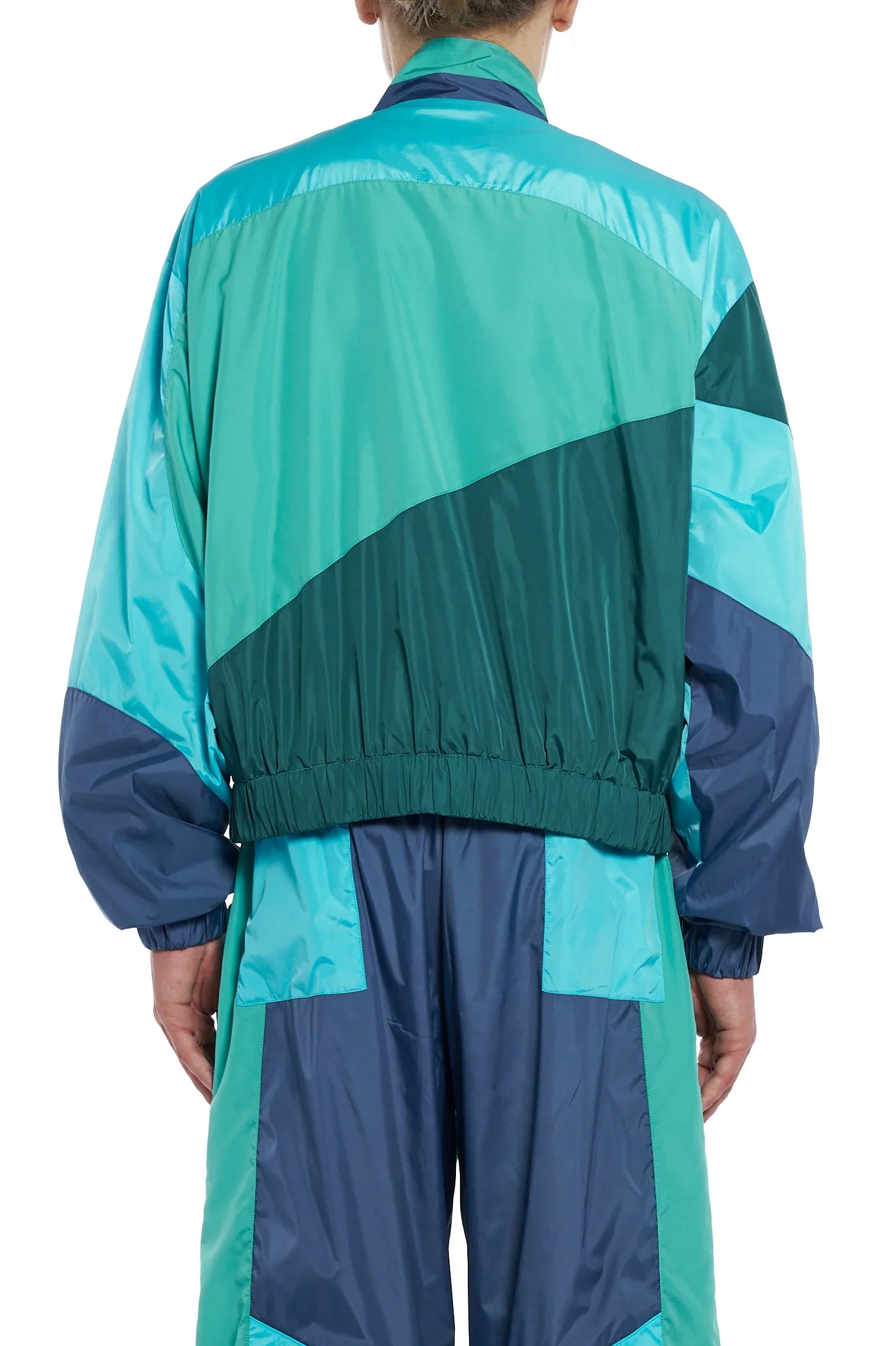 Back view of person wearing green and blue color-block nylon tracksuit jacket and pants