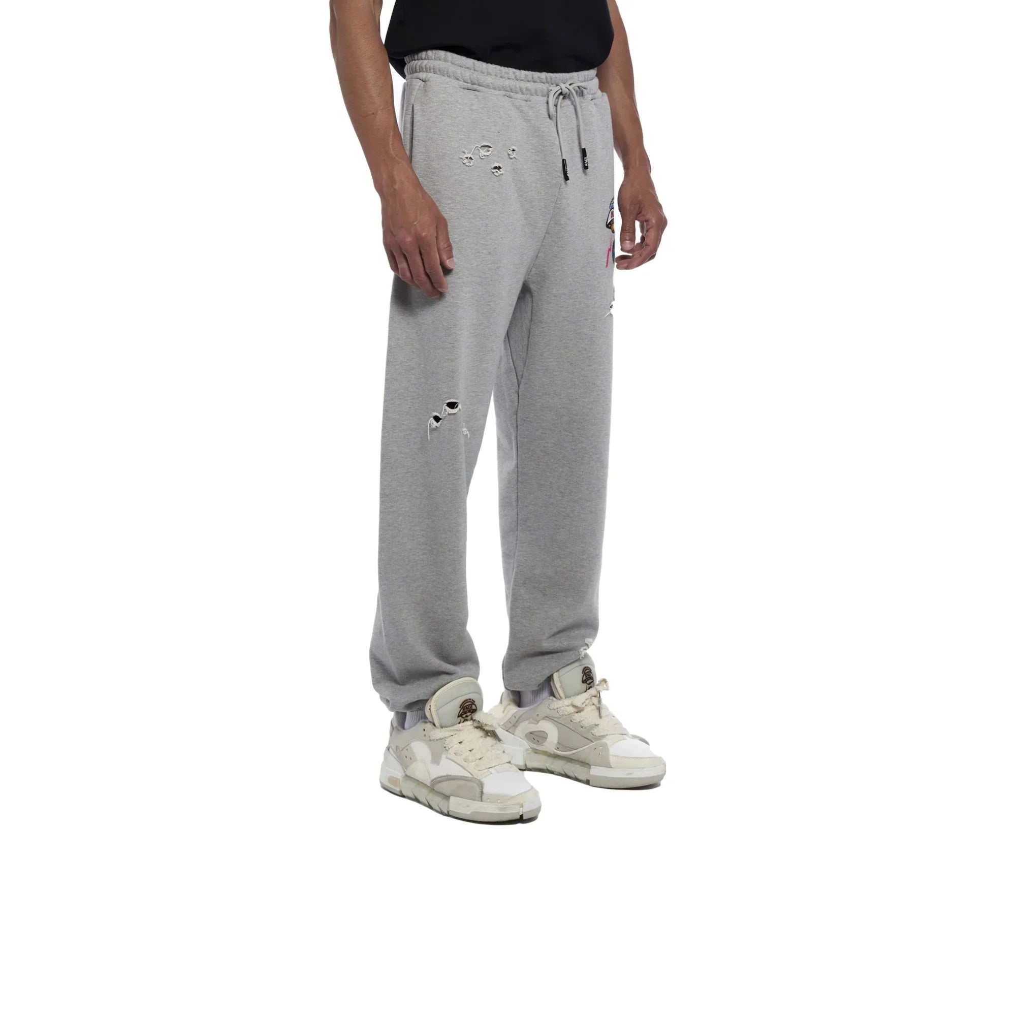Man wearing light grey distressed sweatpants with drawstring waist and white sneakers