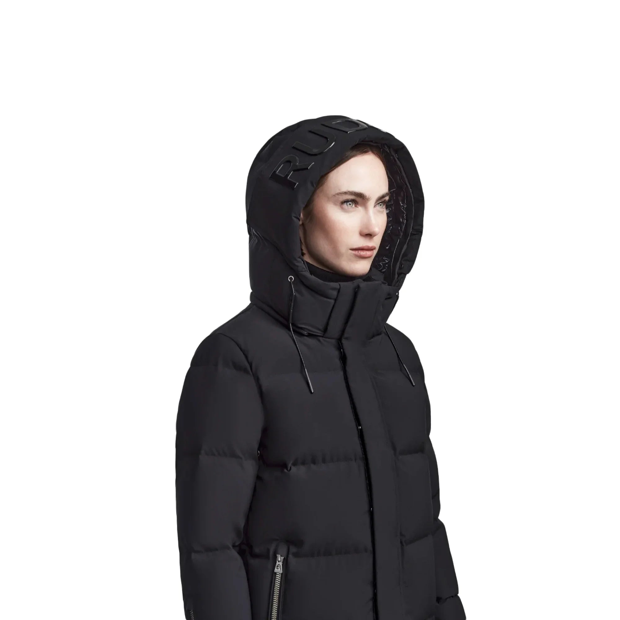 Woman wearing black puffer jacket with a hood featuring raised RUD letters and zippered pockets