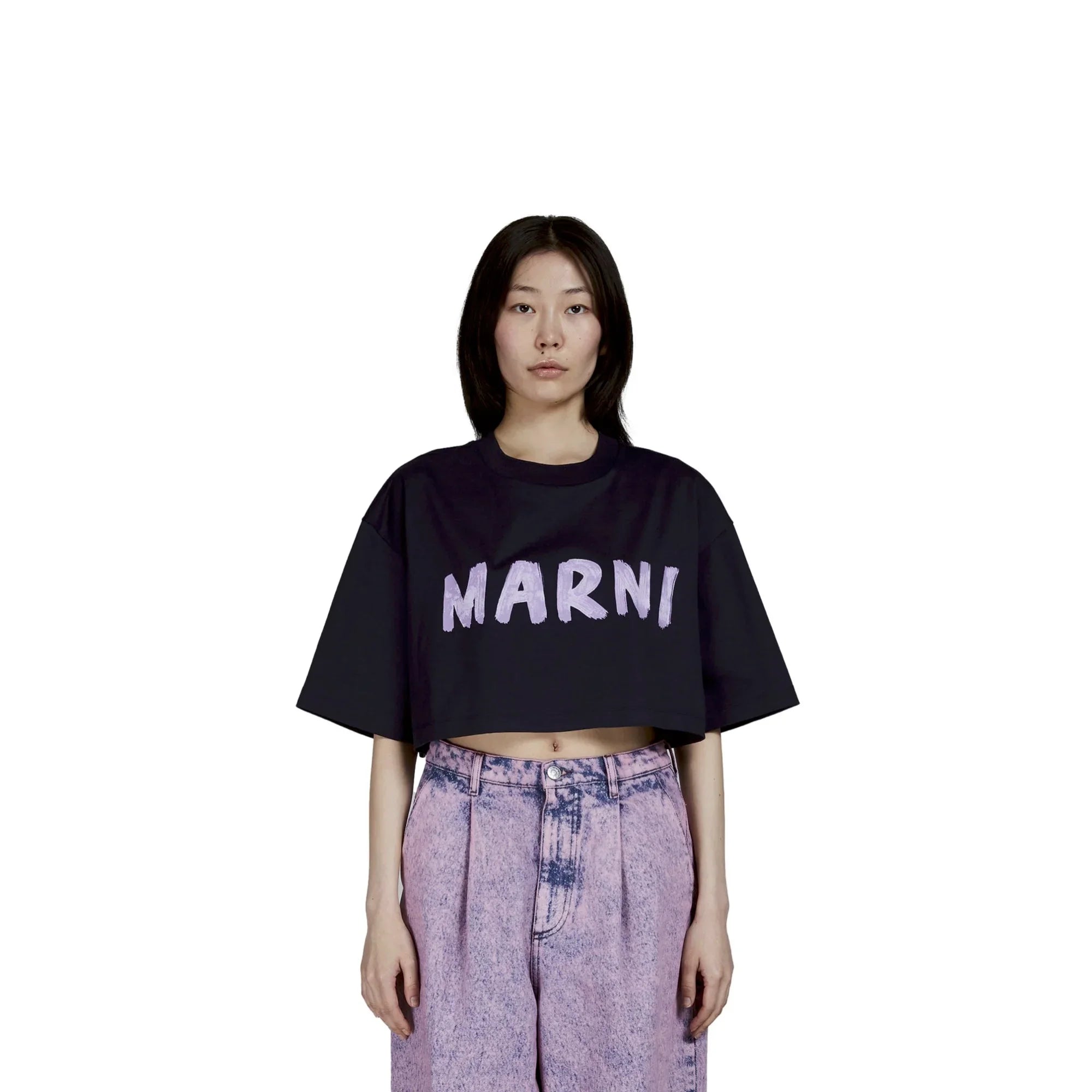 Woman wearing black cropped Marni T-shirt and high-waisted acid wash purple jeans on white background