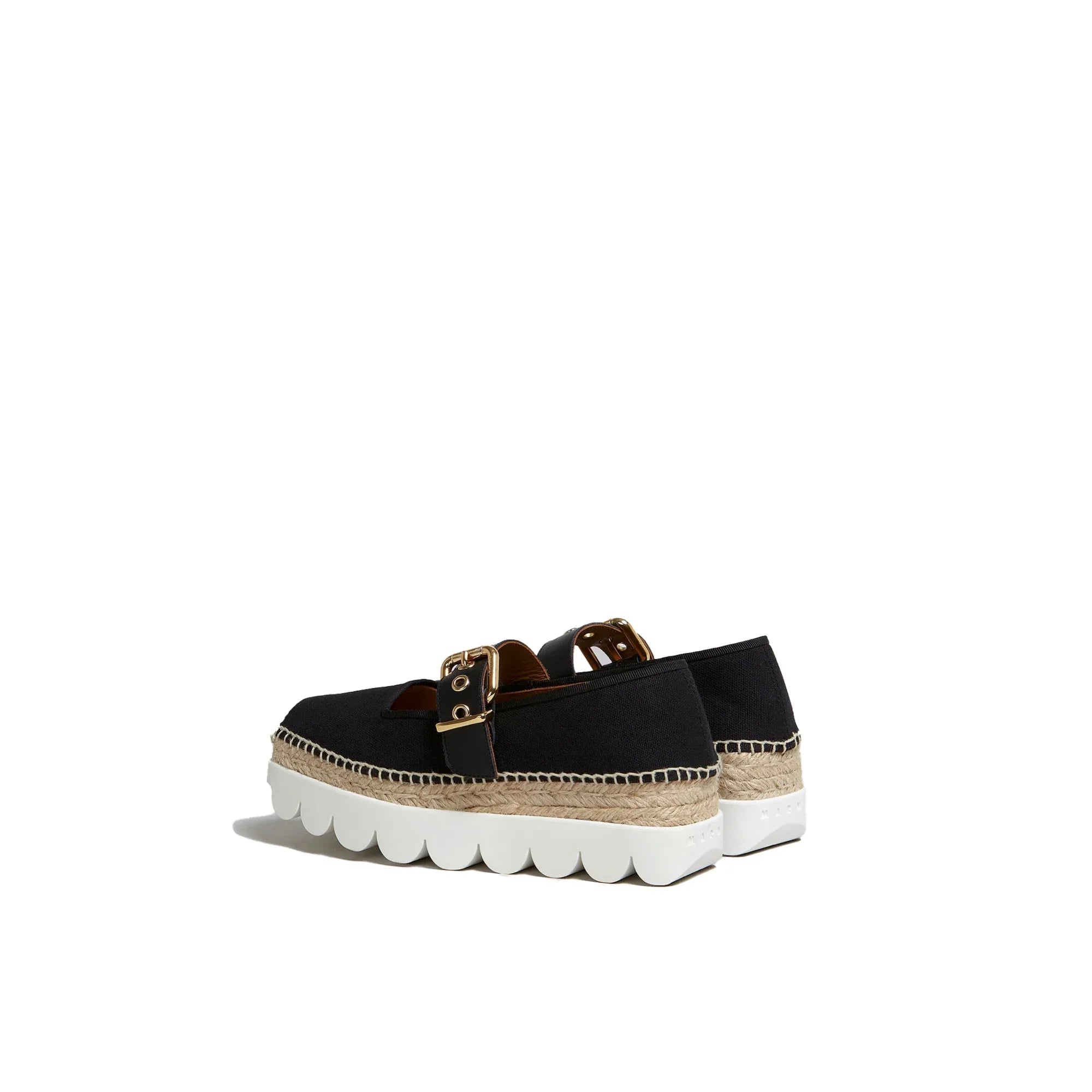 Black platform espadrille shoes with white scalloped rubber soles and gold buckle straps