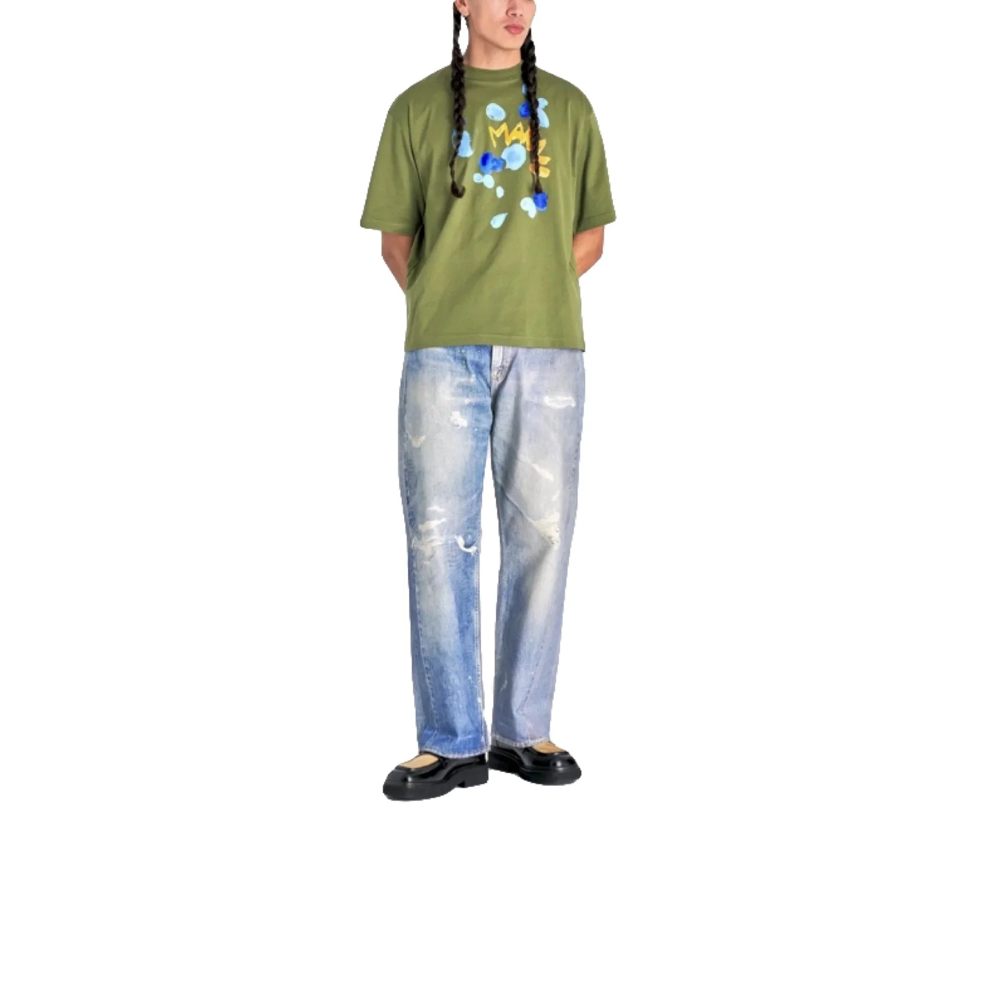 Man wearing olive green graphic t-shirt, light blue distressed jeans, and black shoes on white background