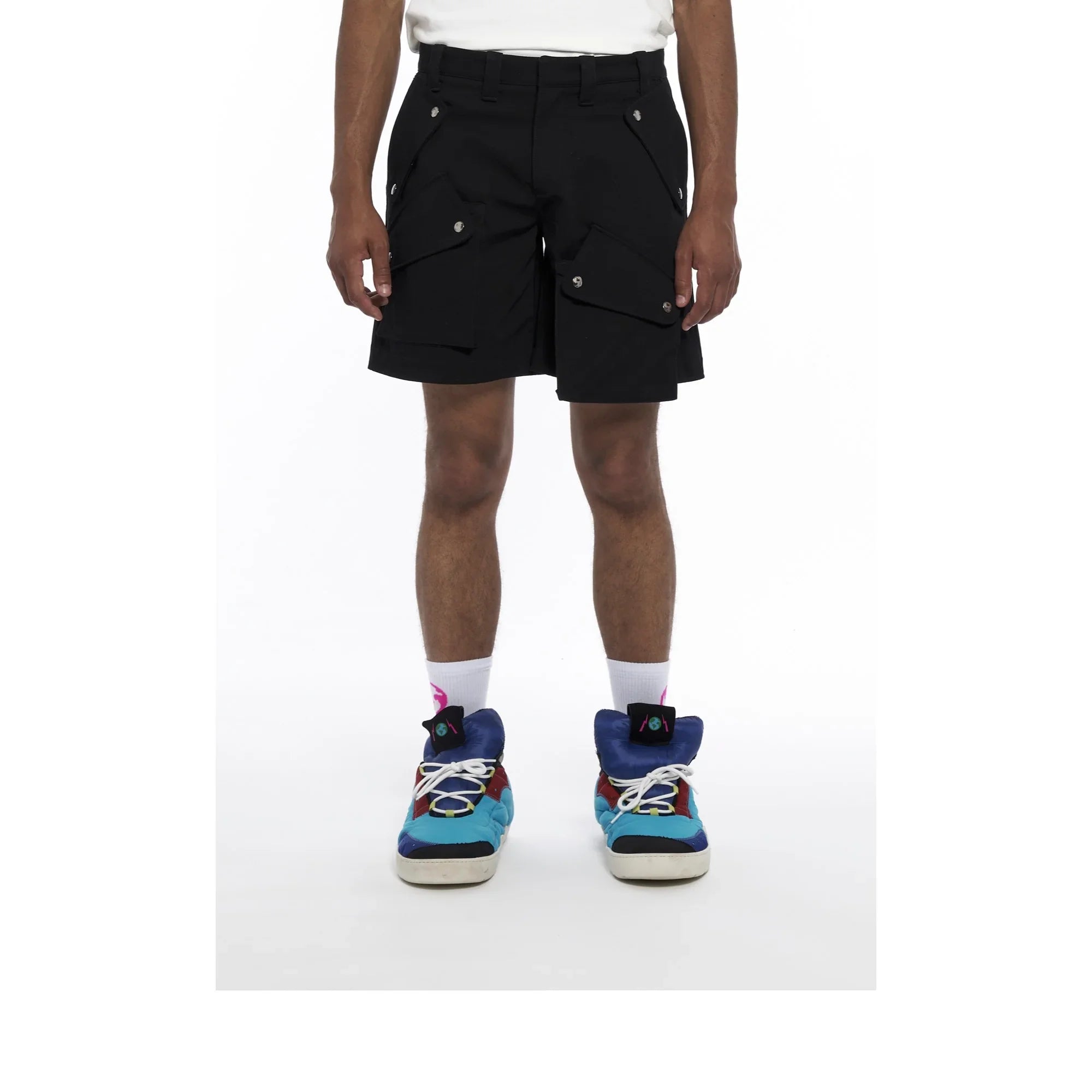 Man wearing black cargo shorts with pockets, white socks, and colorful sneakers on white background