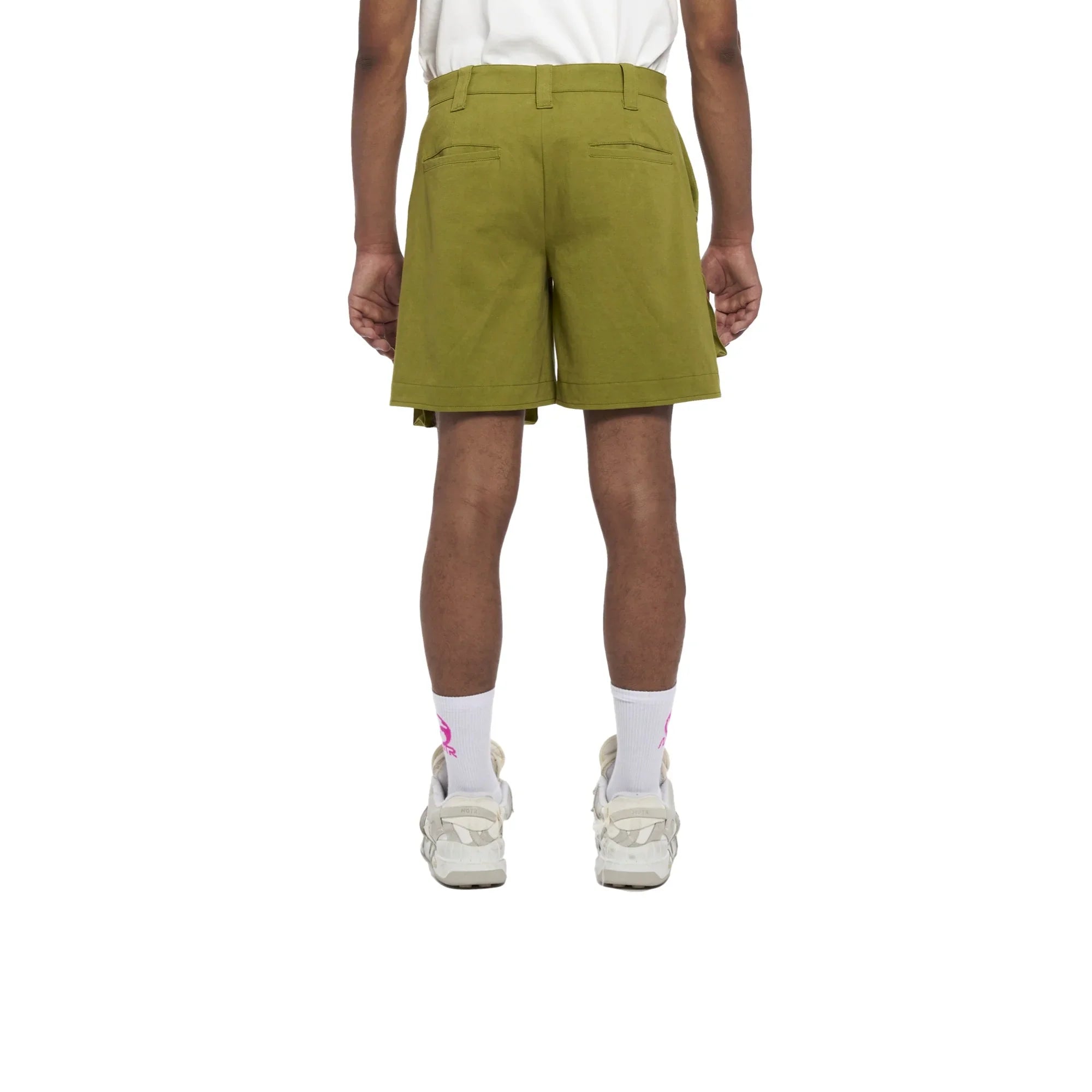 Back view of person wearing olive green shorts, white socks with pink logo, and white sneakers