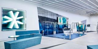 Modern interior design with blue seating area and glass walls.