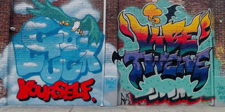 Graffiti art on a brick wall with colorful text and abstract designs.